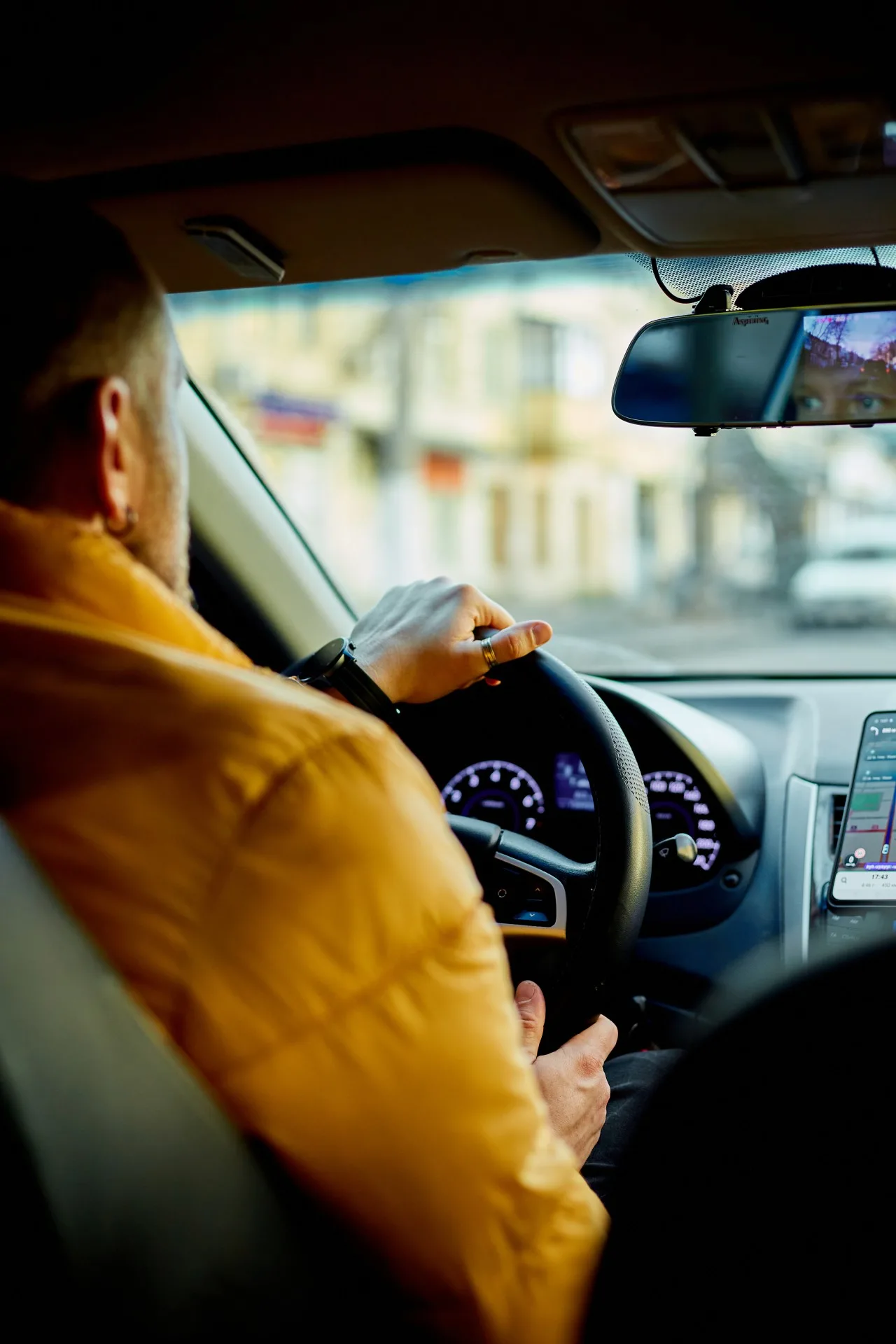 Concentrated bearded man casual clothes driving modern car